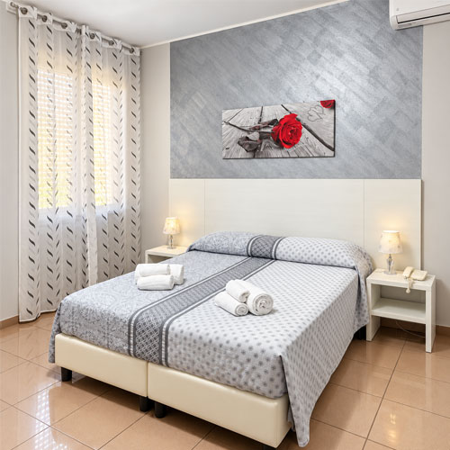Camera matrimoniale dell’Hotel Villa Romana di Piazza Armerina con letto matrimoniale, comodini e aria condizionata